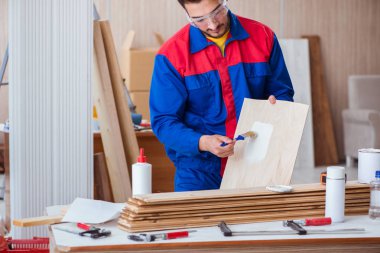 Yooung marangoz boyayla uğraşıyor.