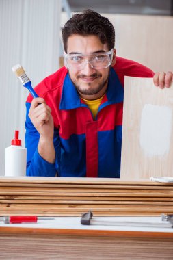 Yooung marangoz boyayla uğraşıyor.