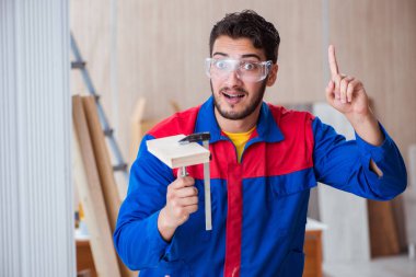 Yooung marangoz boyayla uğraşıyor.