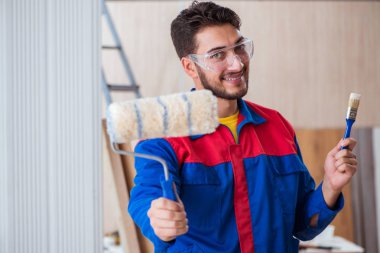 Yooung marangoz boyayla uğraşıyor.