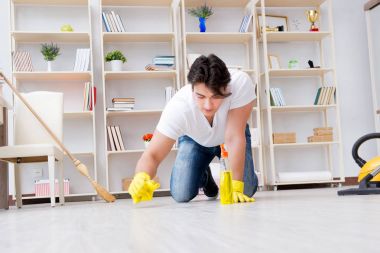 Adam evi temizliyor.