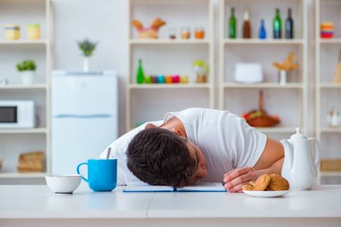 Fazla mesai sonrası kahvaltıda uyuyan bir adam.