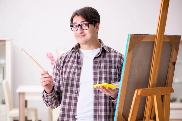 Joven artista masculino dibujando imágenes en estudio brillante —  Fotos de Stock