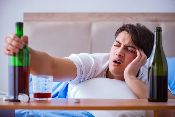 Hombre alcohólico bebiendo en la cama pasando por romper la depresión —  Fotos de Stock