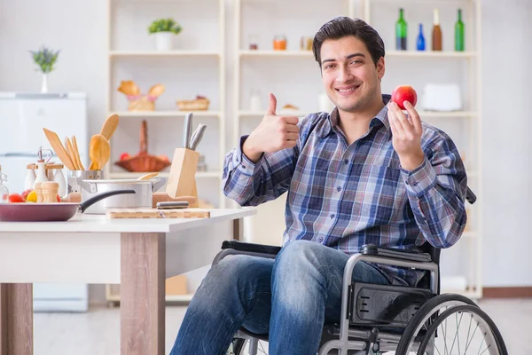 Genç engelli koca yemek salatası hazırlıyor.