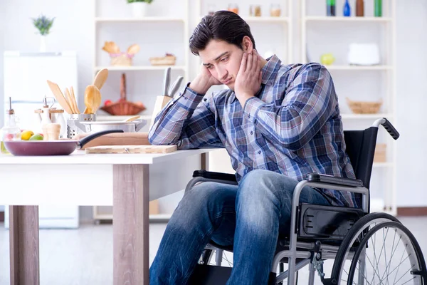 Engelli genç koca mutfakta çalışıyor.