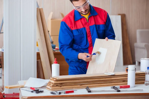 Yooung marangoz boyayla uğraşıyor.