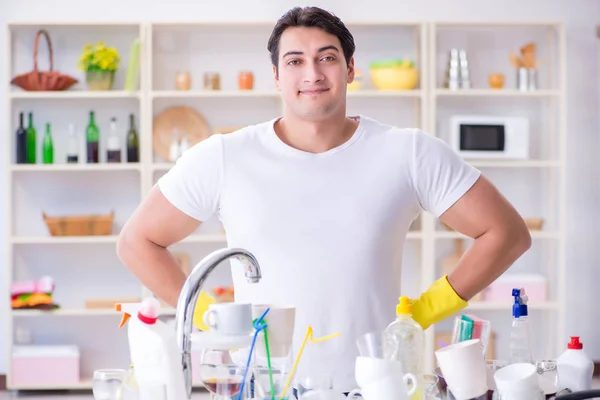 Buen marido lavando platos en casa — Foto de Stock