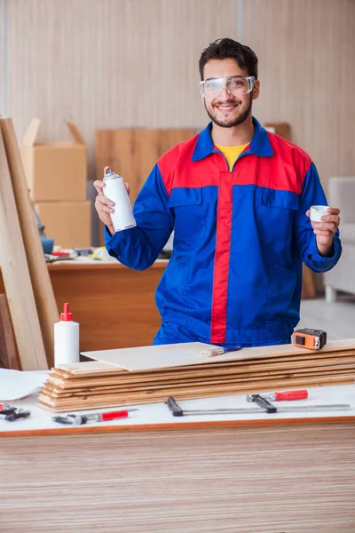 Yooung marangoz boyayla uğraşıyor.