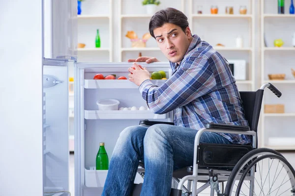 Jonge gehandicapte man die de koelkastdeur opent — Stockfoto