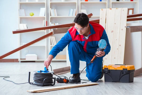 Genç marangoz ahşap kalaslarla çalışıyor.