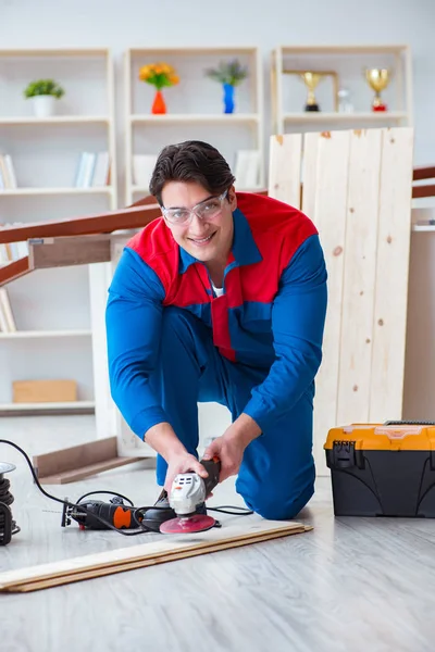 Genç marangoz ahşap kalaslarla çalışıyor.