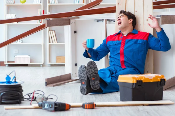 Genç marangoz ahşap kalaslarla çalışmaya ara veriyor.