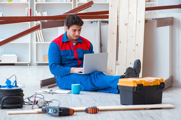 Dizüstü bilgisayarı olan genç bir marangoz