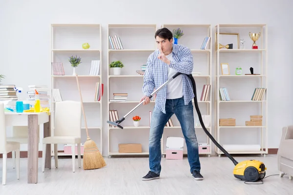 Adam evi temizliyor.