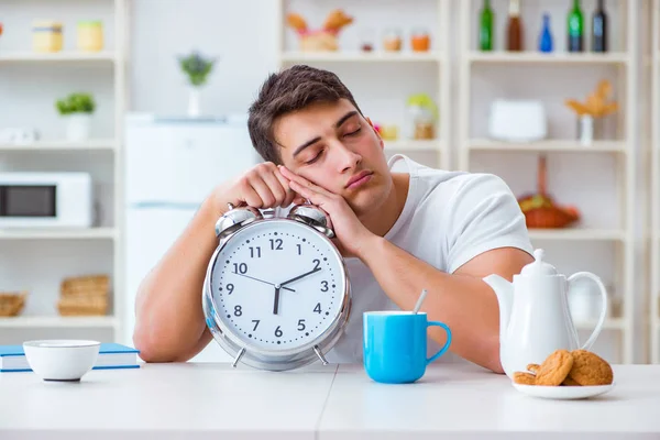 目覚まし時計を持った男が朝食で眠りにつく — ストック写真