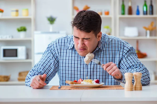 Yemek için evde tatsız yemekler yiyen bir adam.