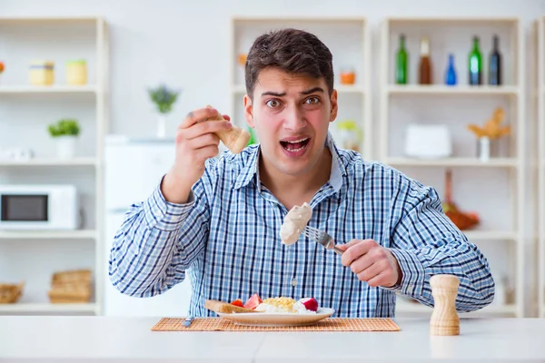 Yemek için evde tatsız yemekler yiyen bir adam.
