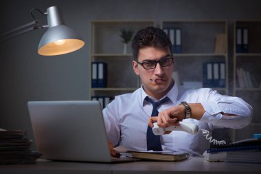 İş adamı telefonda konuşuyor ve ofiste sigara içiyor.