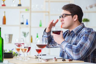Profesyonel şarap garsonu kırmızı şarap tadıyor.