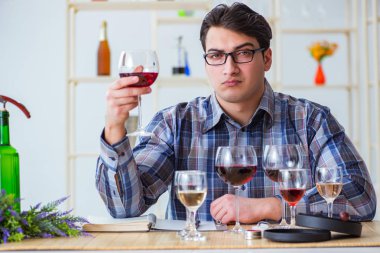 Profesyonel şarap garsonu kırmızı şarap tadıyor.