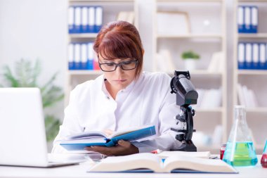 Bir laboratuarda deney yapan kadın bir bilim adamı.