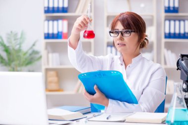 Bir laboratuarda deney yapan kadın bir bilim adamı.