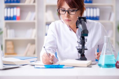 Bir laboratuarda deney yapan kadın bir bilim adamı.