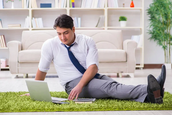 İş adamı ofiste yerde oturuyor.