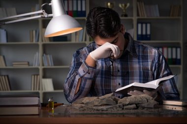 Arkeolog geç saatlere kadar ofiste çalışıyor.