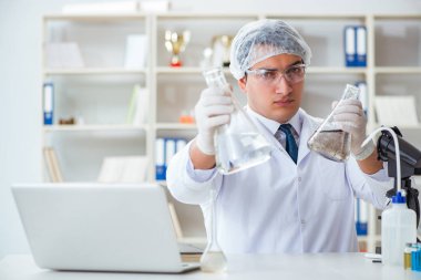 Genç araştırmacı bilim adamı bir su testi kirliliği araştırması yapıyor.