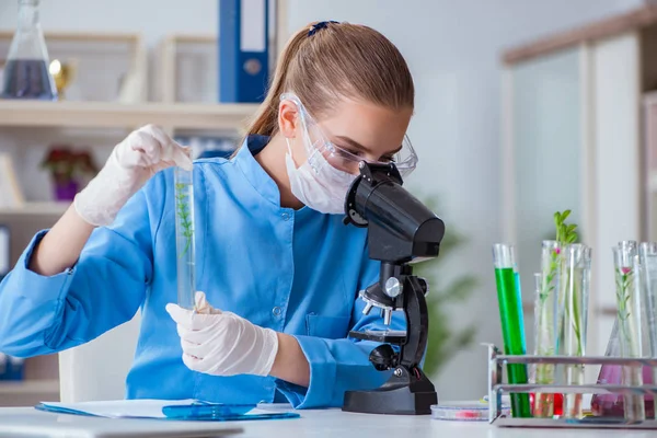 Bir laboratuarda deney yapan kadın bir bilim adamı.