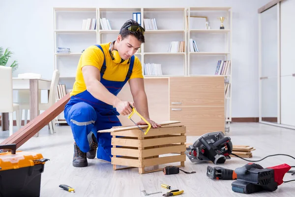 Tamirci marangoz ahşap bir tahtayı kesiyor.