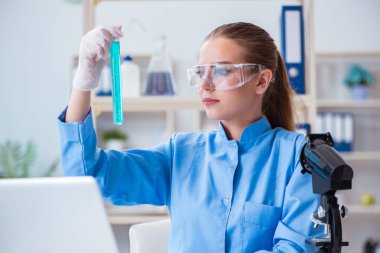 Bir laboratuarda deney yapan kadın bir bilim adamı.