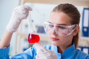 Bir laboratuarda deney yapan kadın bir bilim adamı.