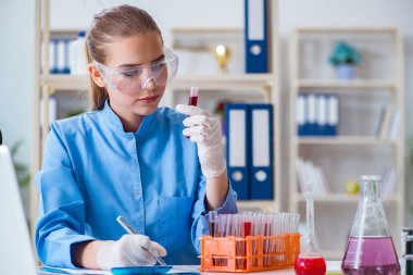 Bir laboratuarda deney yapan kadın bir bilim adamı.