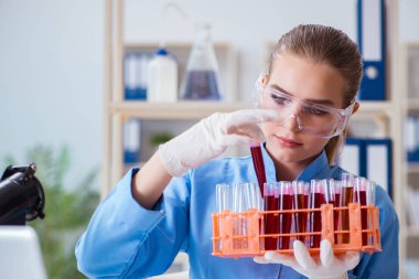 Bir laboratuarda deney yapan kadın bir bilim adamı.