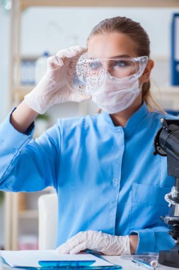 Bir laboratuarda deney yapan kadın bir bilim adamı.