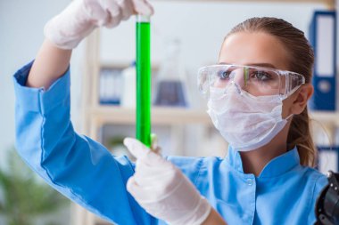 Bir laboratuarda deney yapan kadın bir bilim adamı.