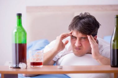 Yatakta içen alkolik adam depresyona giriyor.