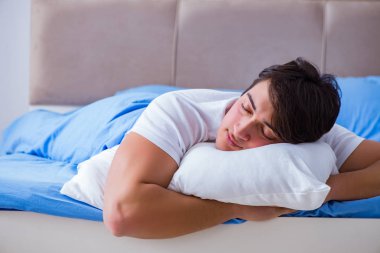 Uykusuzluk çeken bir adam yatakta yatıyor.