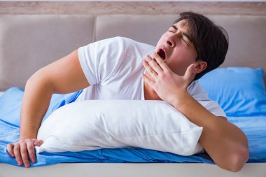 Uykusuzluk çeken bir adam yatakta yatıyor.