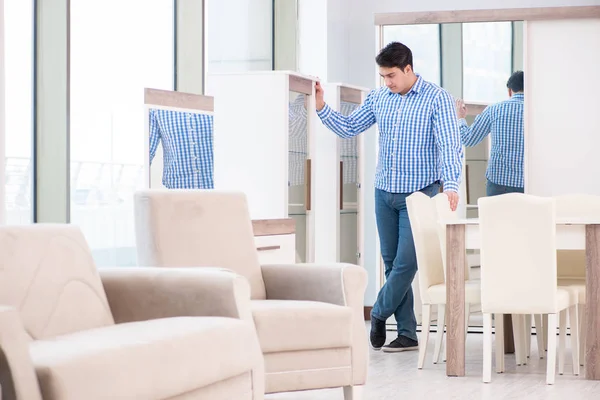 Genç adam mobilya dükkanından alışveriş yapıyor.