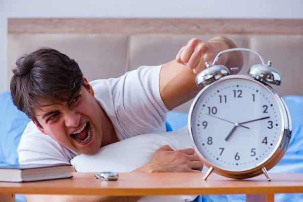 Homem na cama frustrado sofrendo de insônia com um coágulo de alarme — Fotografia de Stock