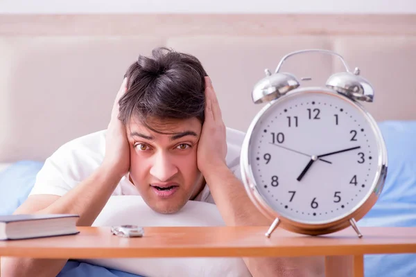 Uomo a letto frustrato soffre di insonnia con un blocco di allarme — Foto Stock