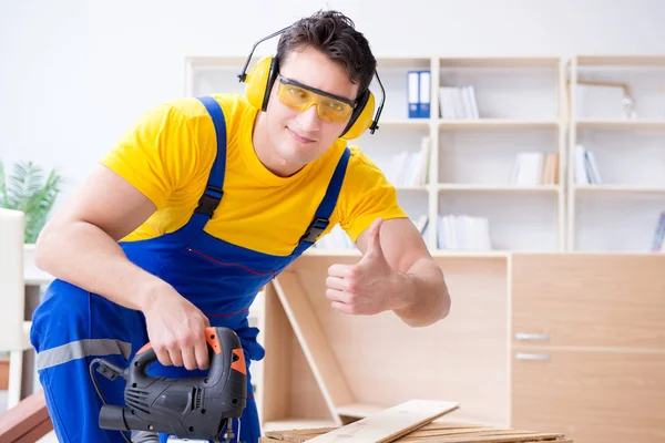 Tamirci marangoz bir seçimle tahta tahtayı kesiyor.