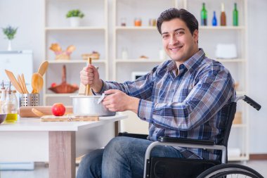 Engelli adam mutfakta çorba hazırlıyor.