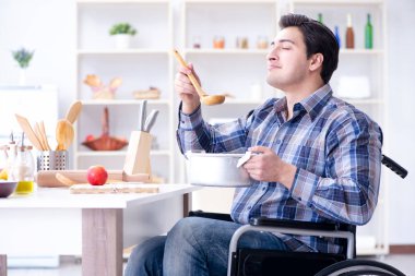 Engelli adam mutfakta çorba hazırlıyor.