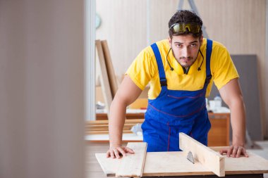 Genç bir marangoz dairesel testere ile çalışıyor.