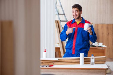 Yooung marangoz boyayla uğraşıyor.